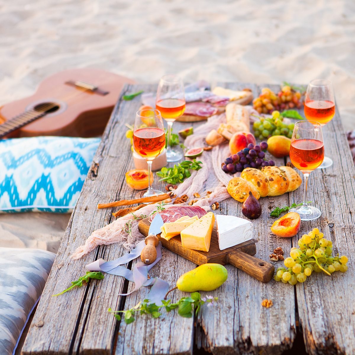 Picnic on the beach at sunset in the style of boho, food and drink