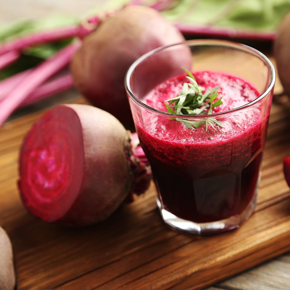 Fresh beets juice in glass on a grey wooden table