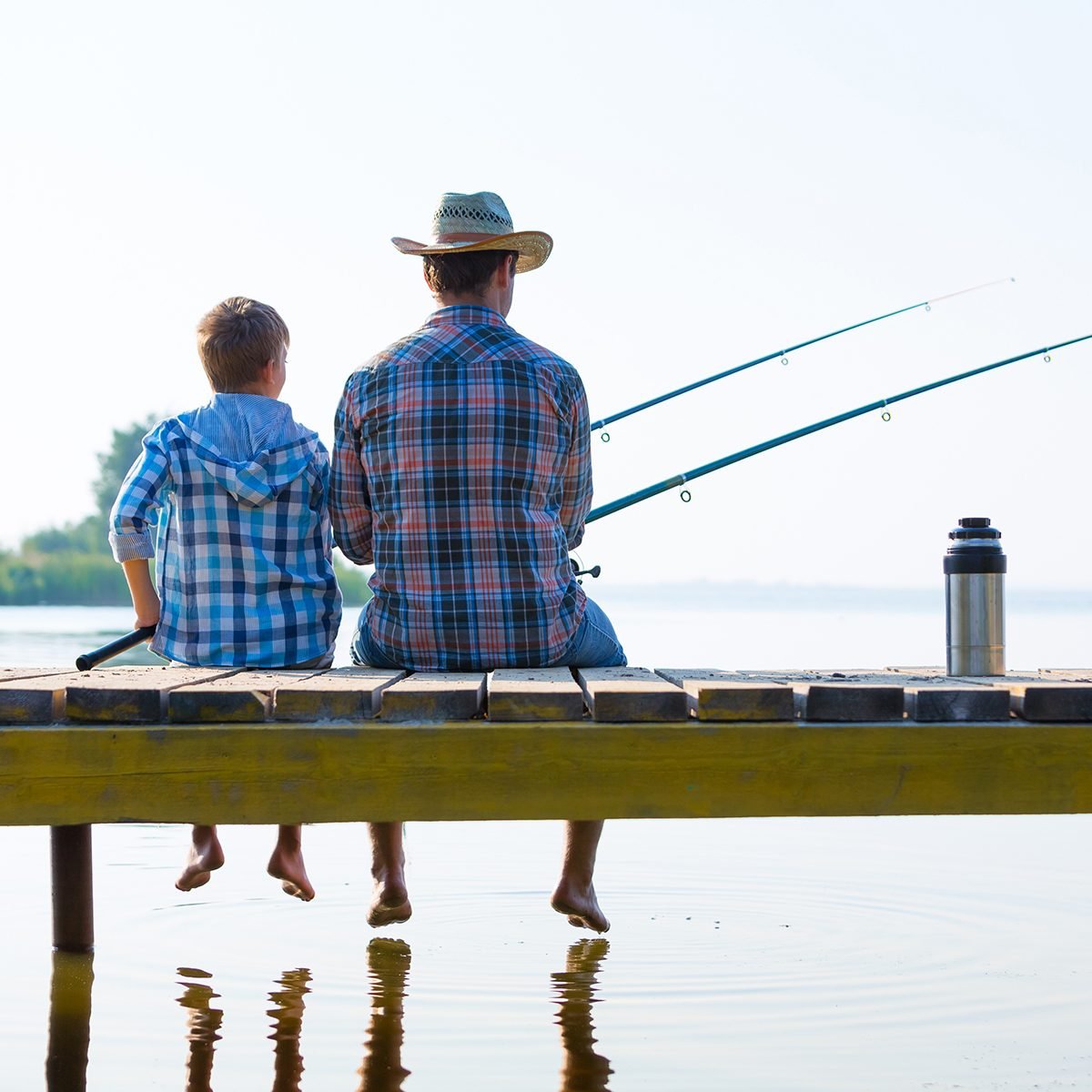 boy and his father fishing together from a pier
