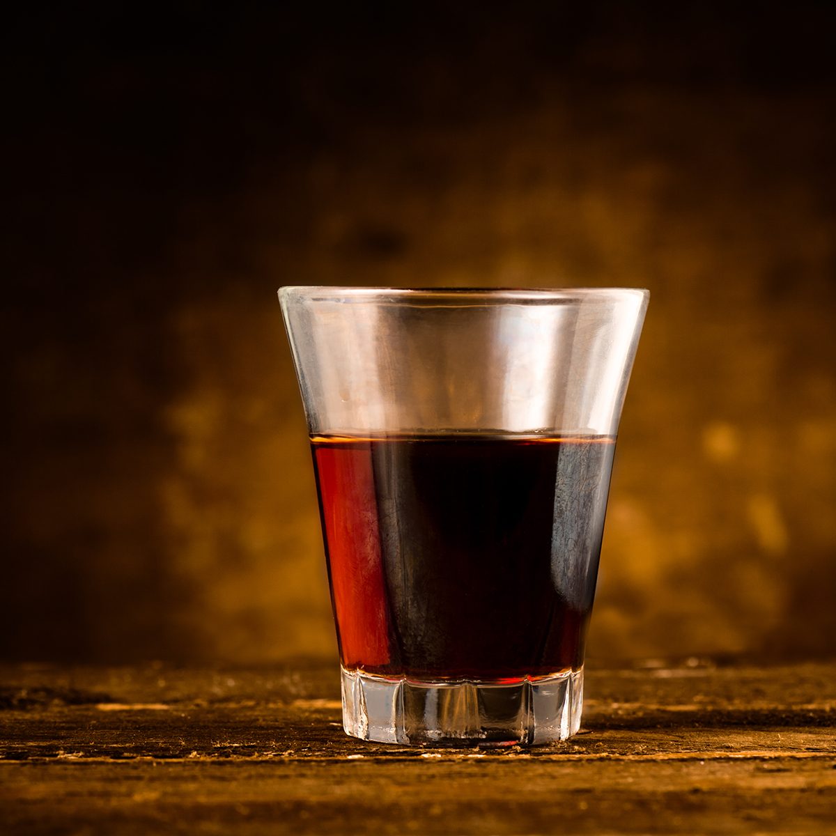Shot of Alcoholic Bitter Liquor on Wooden Surface