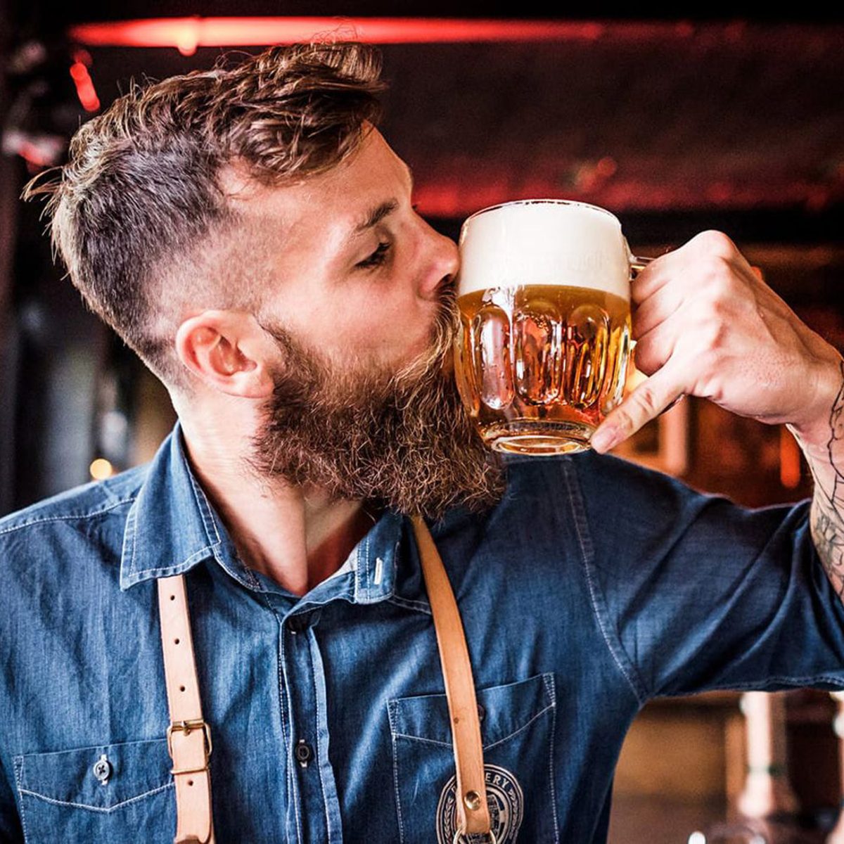Man kissing a glass of Pilsner Urquell