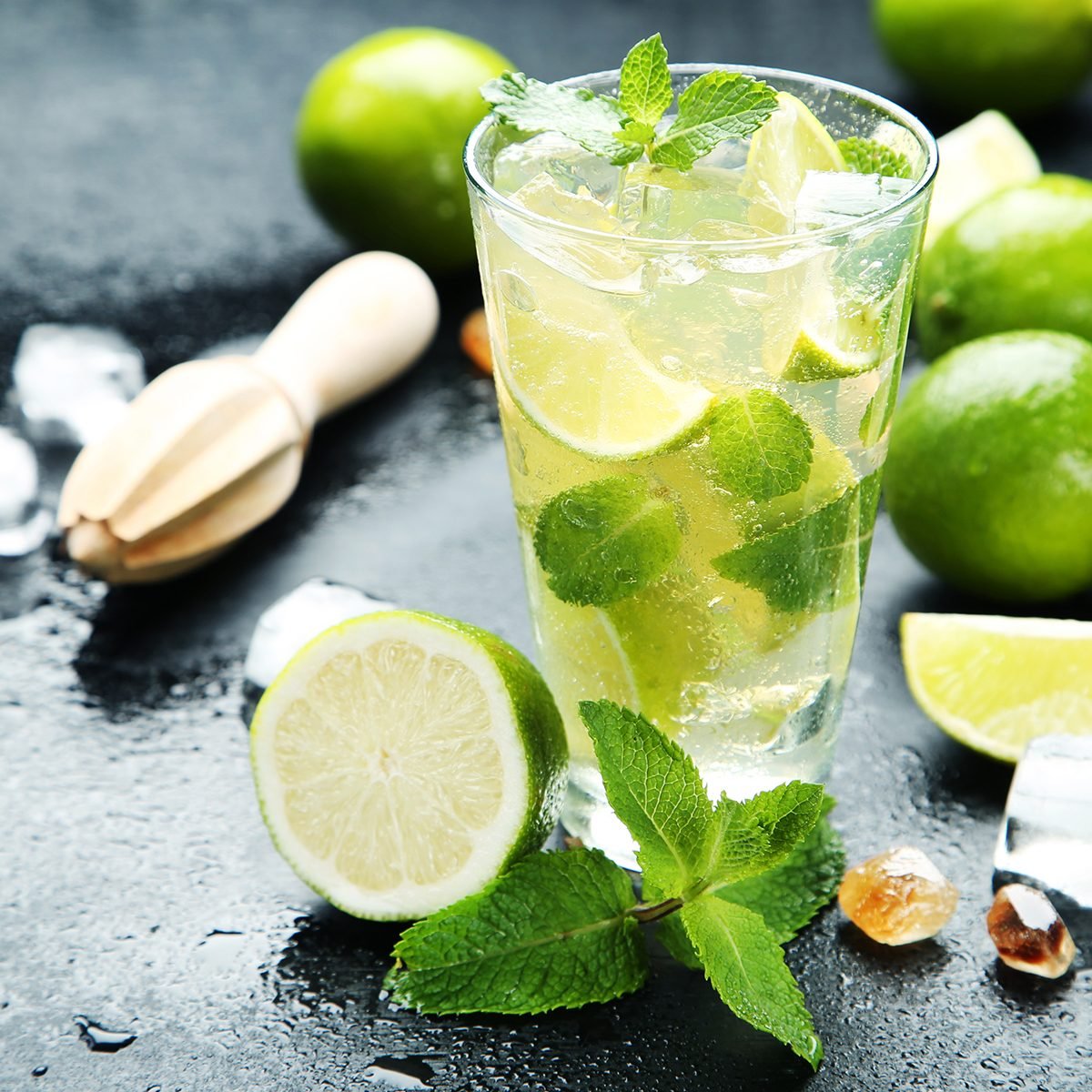 Mojito cocktail in glass with sugar on wooden table