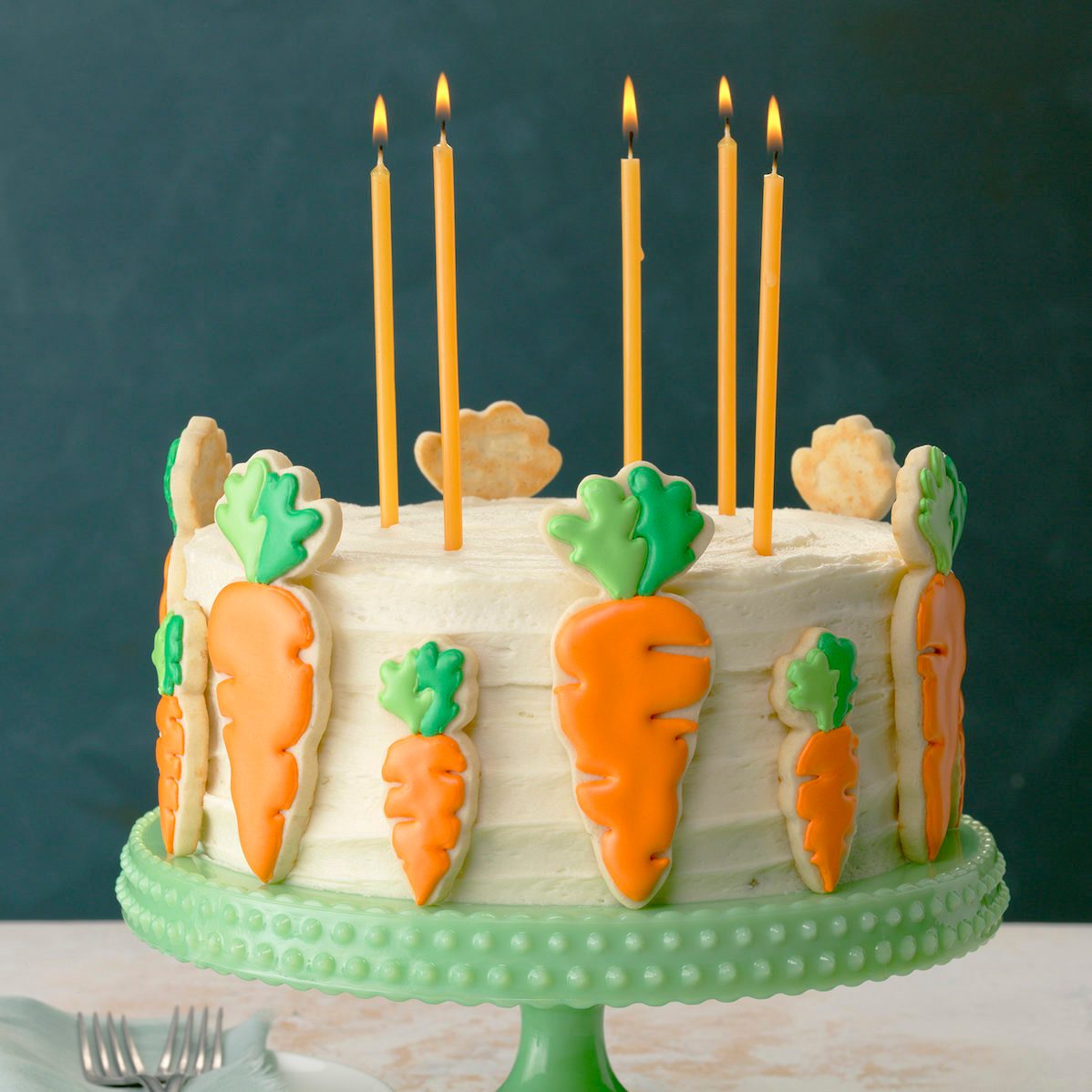 green pedistal; aqua linen; green wall; forks; light painted surface; candles