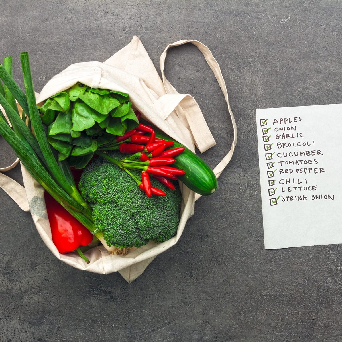Shopping bag full of vegetables and fruits with checked shopping list.
