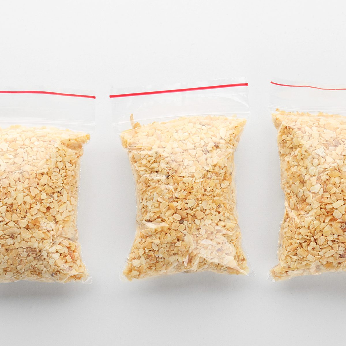 Ziploc bags with granulated dried garlic on white background