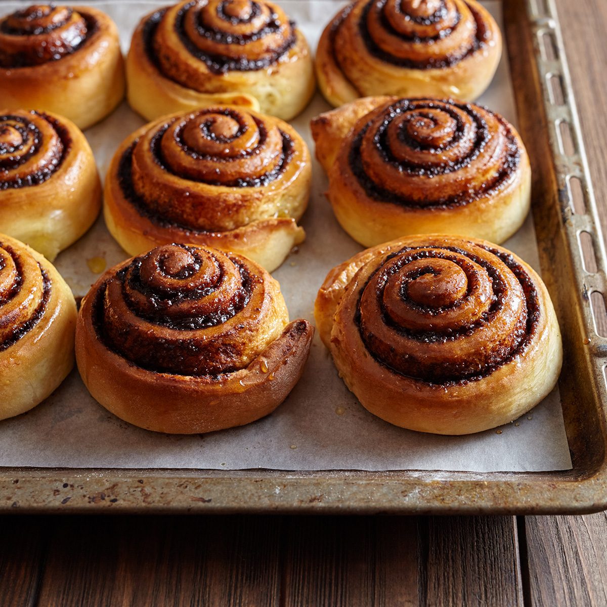 Freshly baked cinnamon rolls buns with cocoa and spices on a metal a baking sheet.