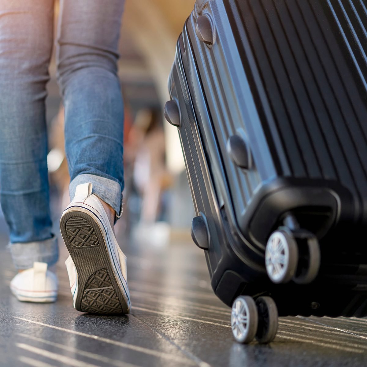 Person wheeling luggage through airport