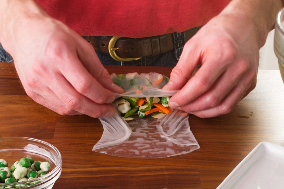 A person wrapping homemade spring rolls.