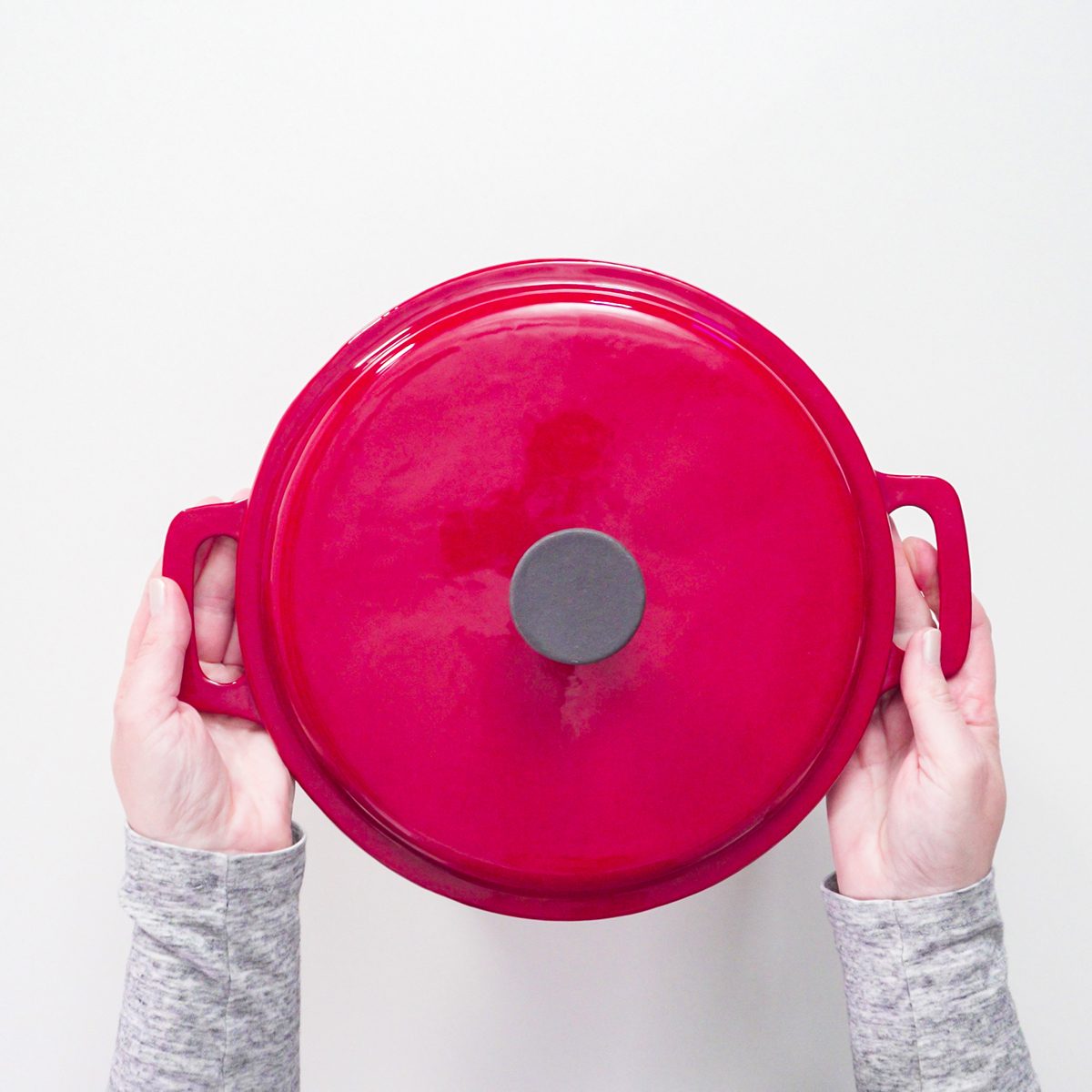 Flat lay. Red, white, and blue enameled cast iron covered dutch oven on a white background.