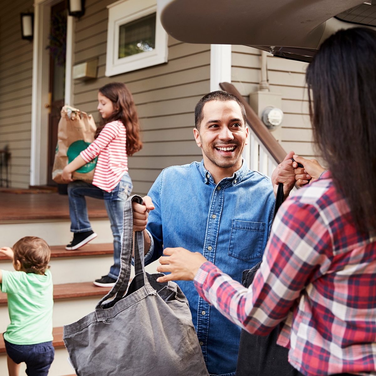 Family Unloading Shopping Bags From Car
