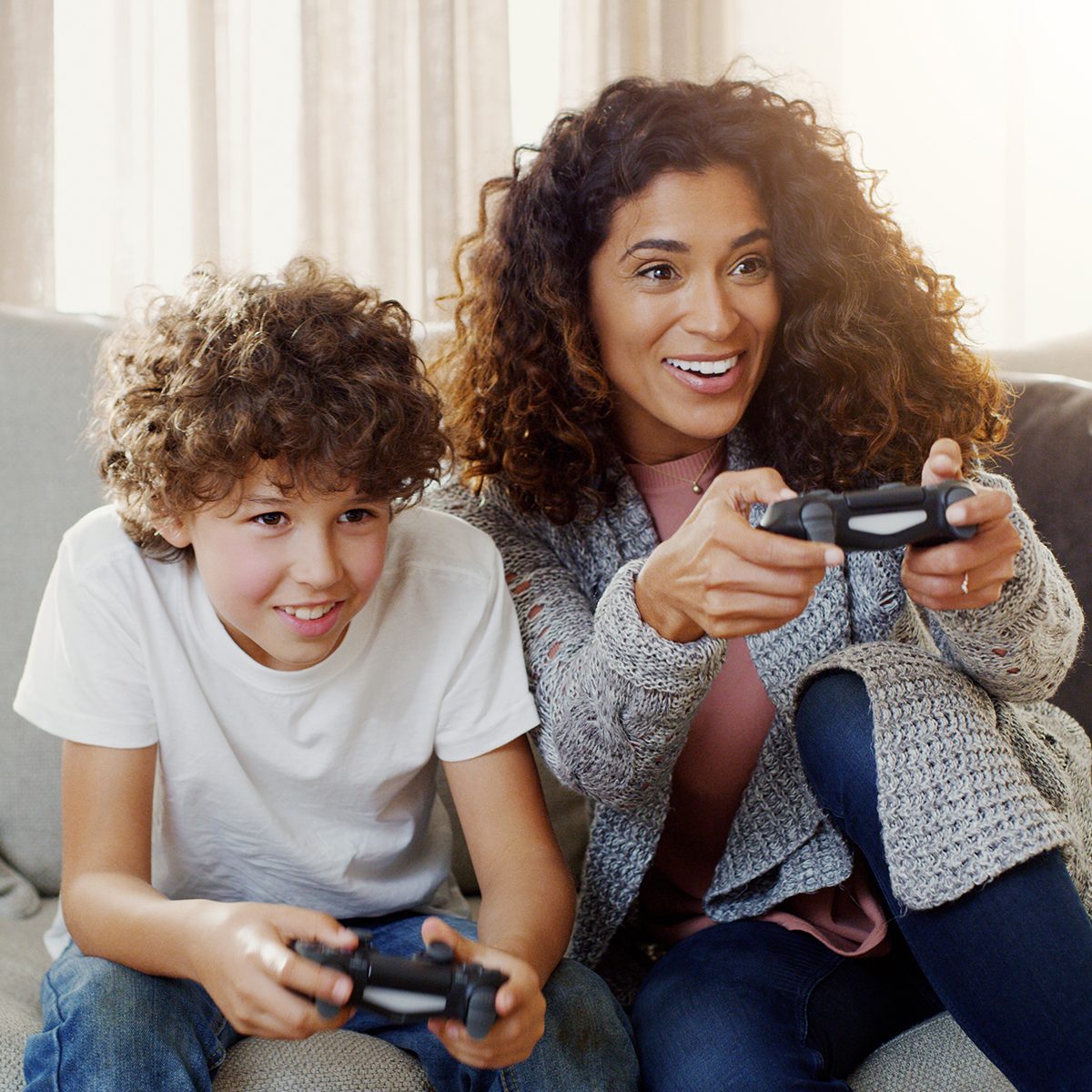 Shot of a young mother and her son playing video games together at home