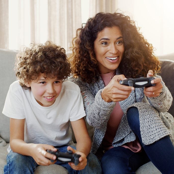 Shot of a young mother and her son playing video games together at home