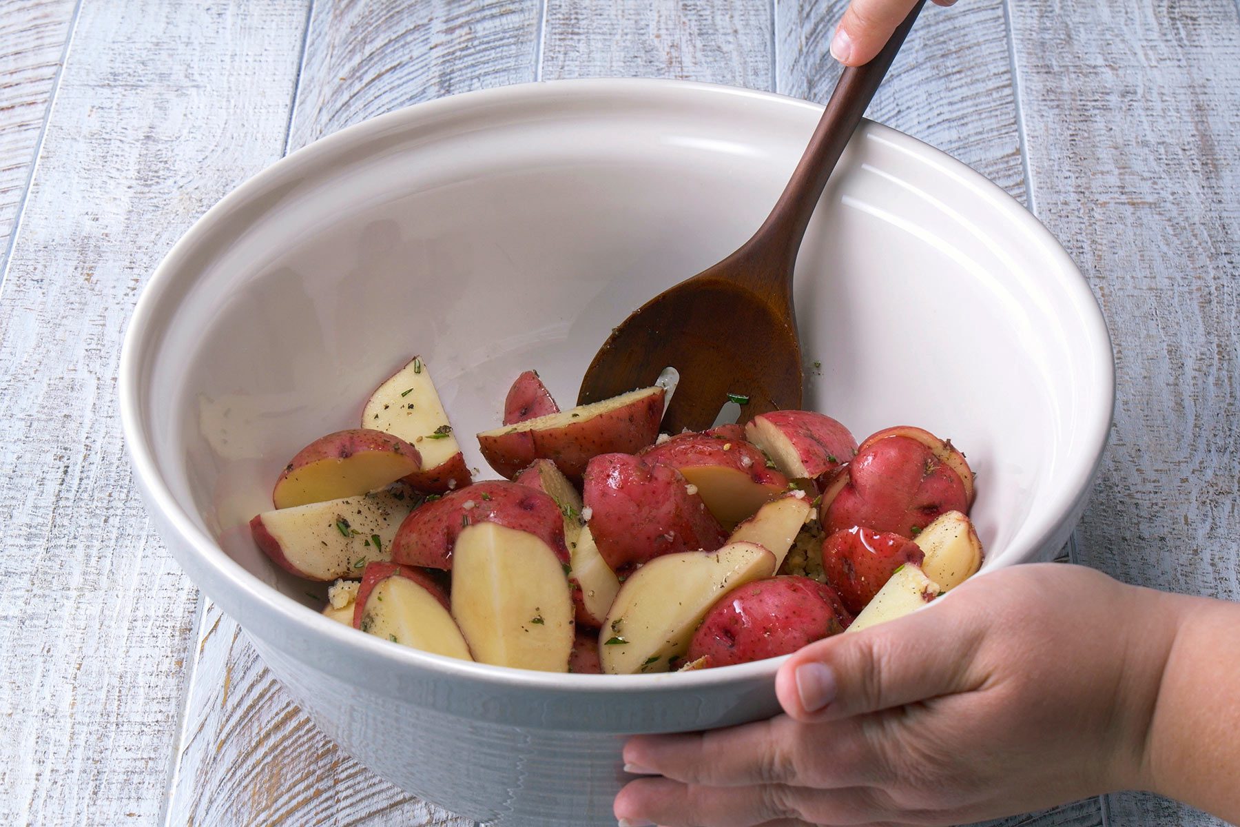 Tossing the Potatoes in Oil, rosemary and salt 