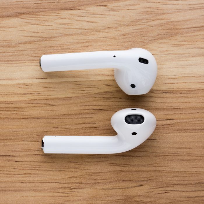 Rostov-on-Don, Russia - September 2018:The airpods headset lies on a wooden table. Wireless headphones close-up.