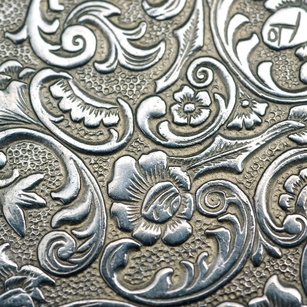 Close up details of engraved back of an old pocket watch.