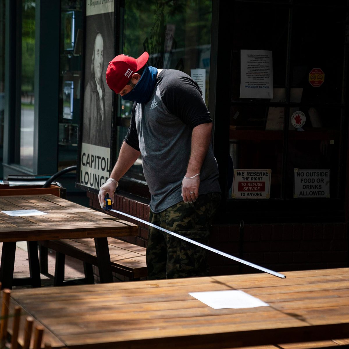 Masked man measuring table distance