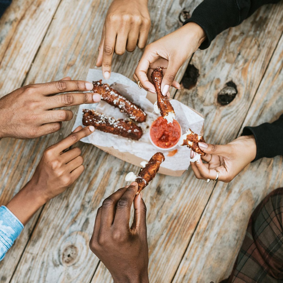 Close up image of friends having mozzarella sticks