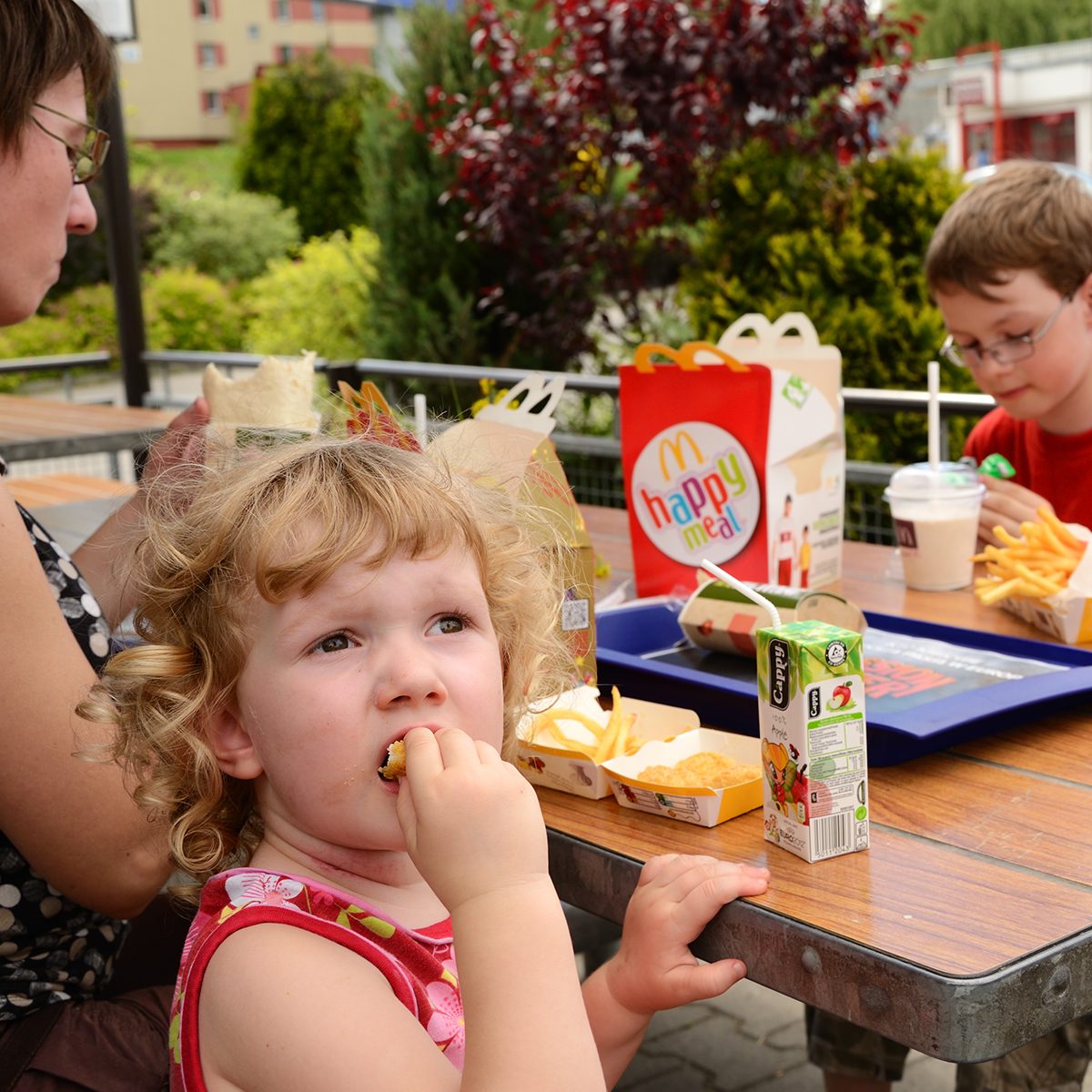 "Krakow, Poland - June 8th, 2012: Mother with two kids having a lunch in McDonald