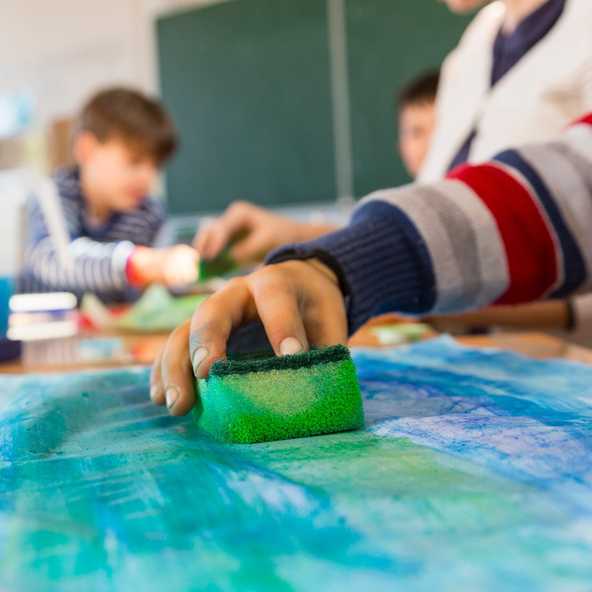 hand of a child painting in a primary school