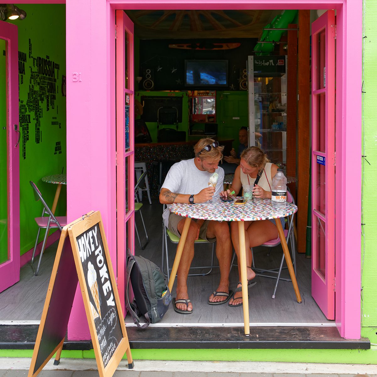 Picton, Marlborough Sounds/New Zealand - February 1, 2020: Tourists eating ice creams engrossed with their cellphones in an ice cream shop in Picton, Marlborough Sounds, New Zealand.