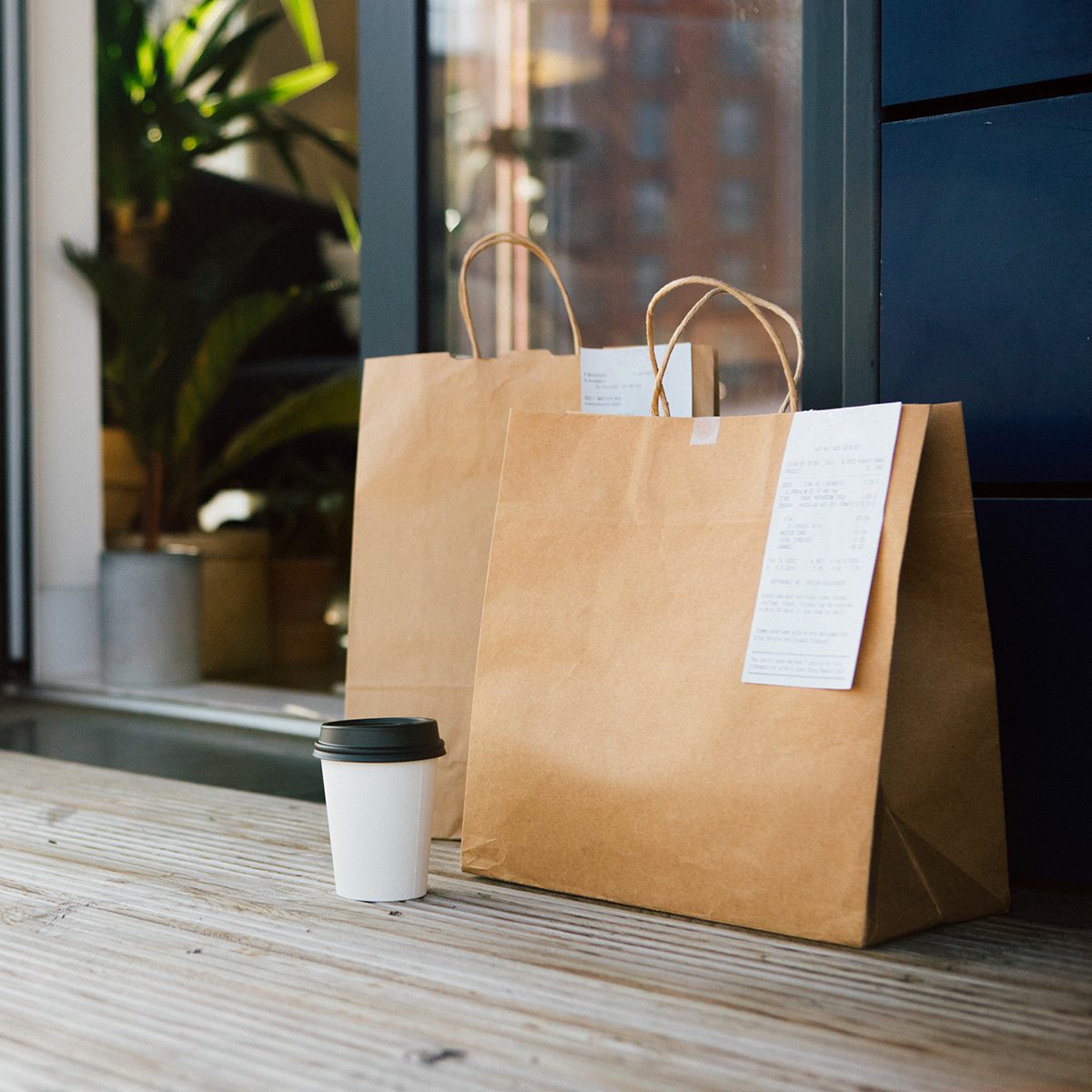 Takeaway meal packed in brown paper bag delivered to the front door of a residential building.