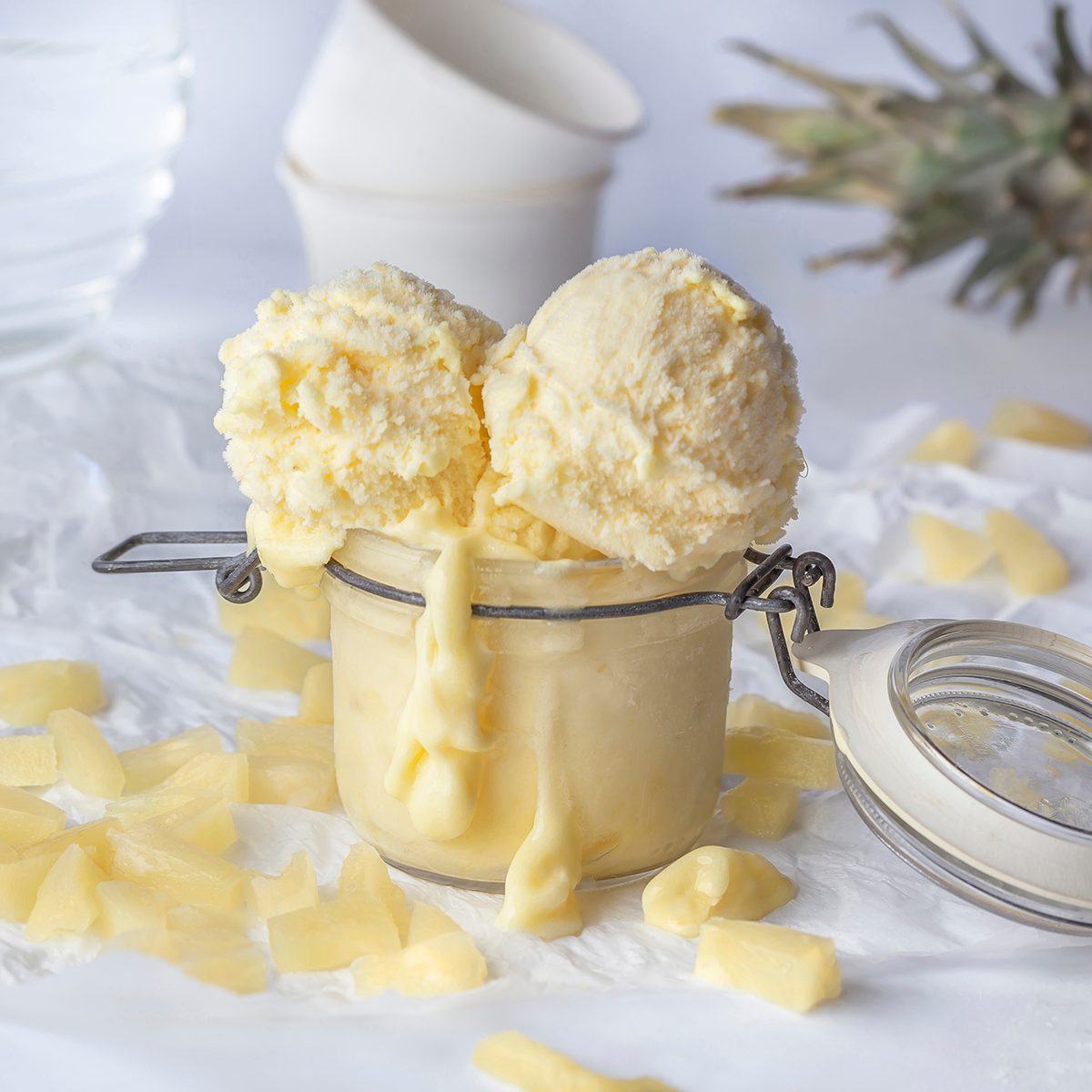 Stevia with pineapple ice cream balls decorated with pineapple slices and whole fruit on white background