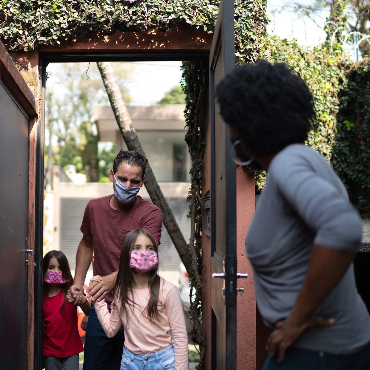 Welcoming friends at home during pandemic using surgical mask