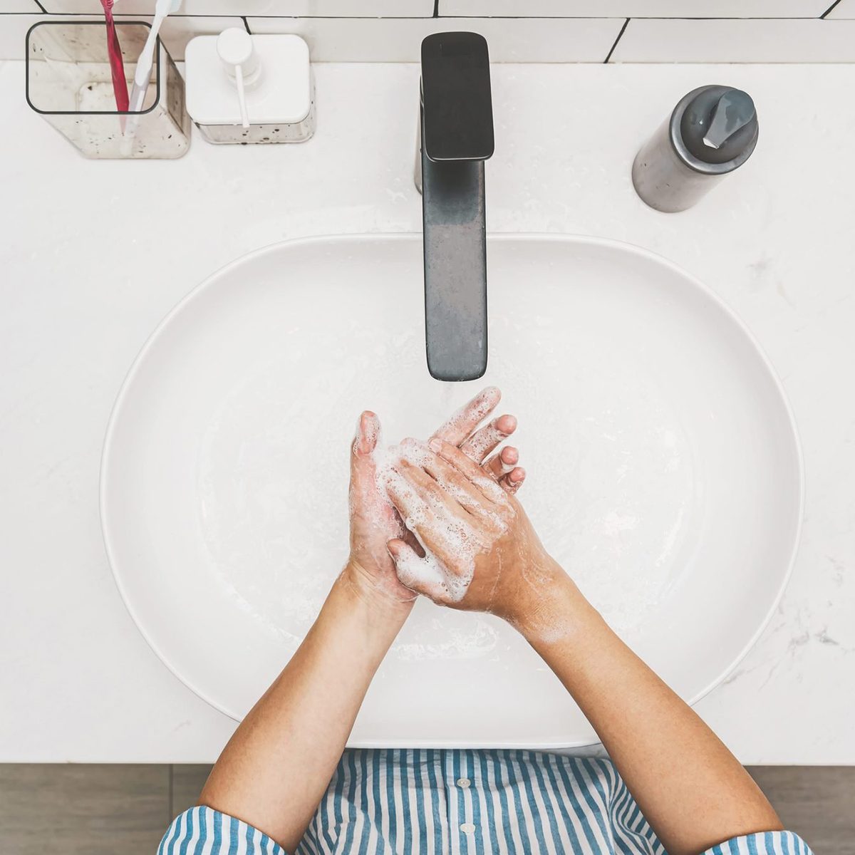 Health care of Covid-19 pandemic concept, Top view Asian hand washing with faucet water in Bathroom at home