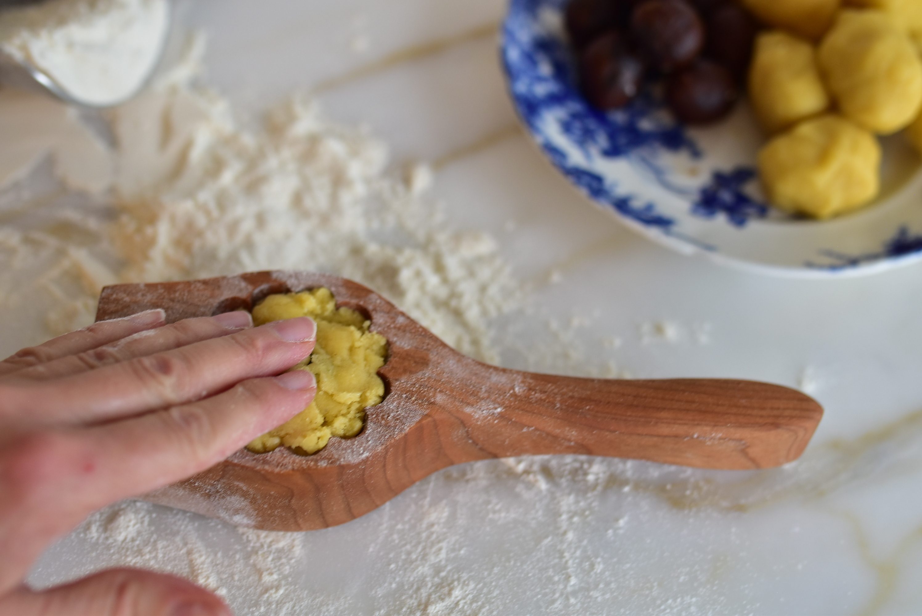Fingertips press the top of the dough to fill ma'amoul cookies
