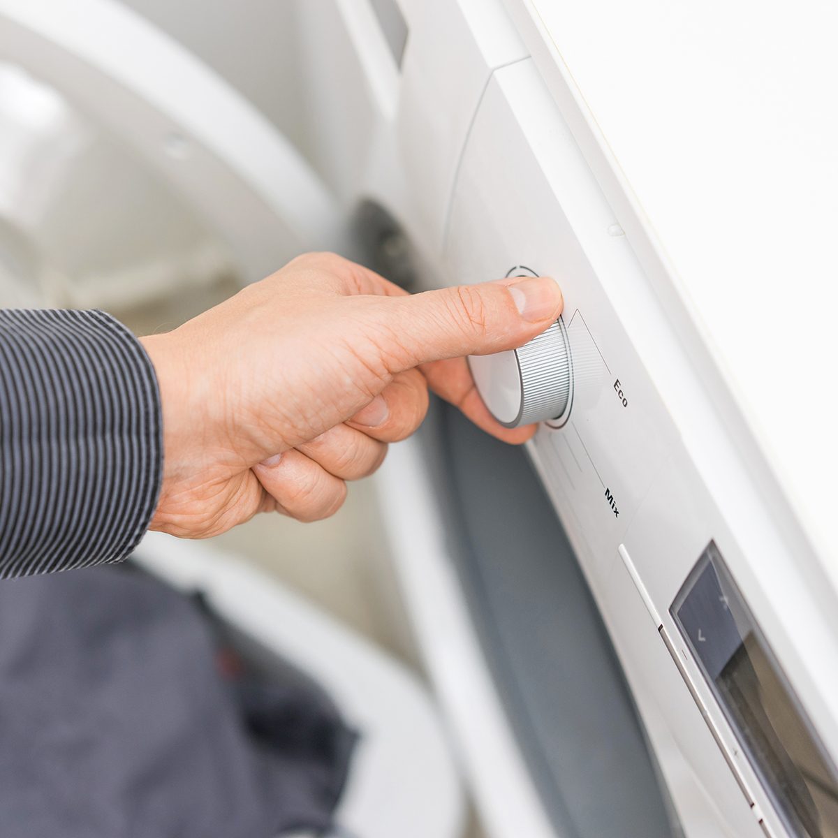 Man Is Choosing Eco Program On The Washing Machine,