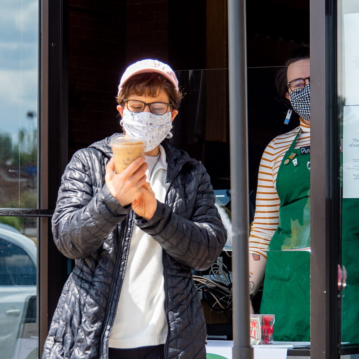 A Starbucks customer checks to ensure her order is correct as Ohio businesses reopen in the wake of the Coronavirus COVID-19 pandemic, Tuesday, May 12, 2020, in Cincinnati, Ohio, United States. (Photo by Jason Whitman/NurPhoto via Getty Images)