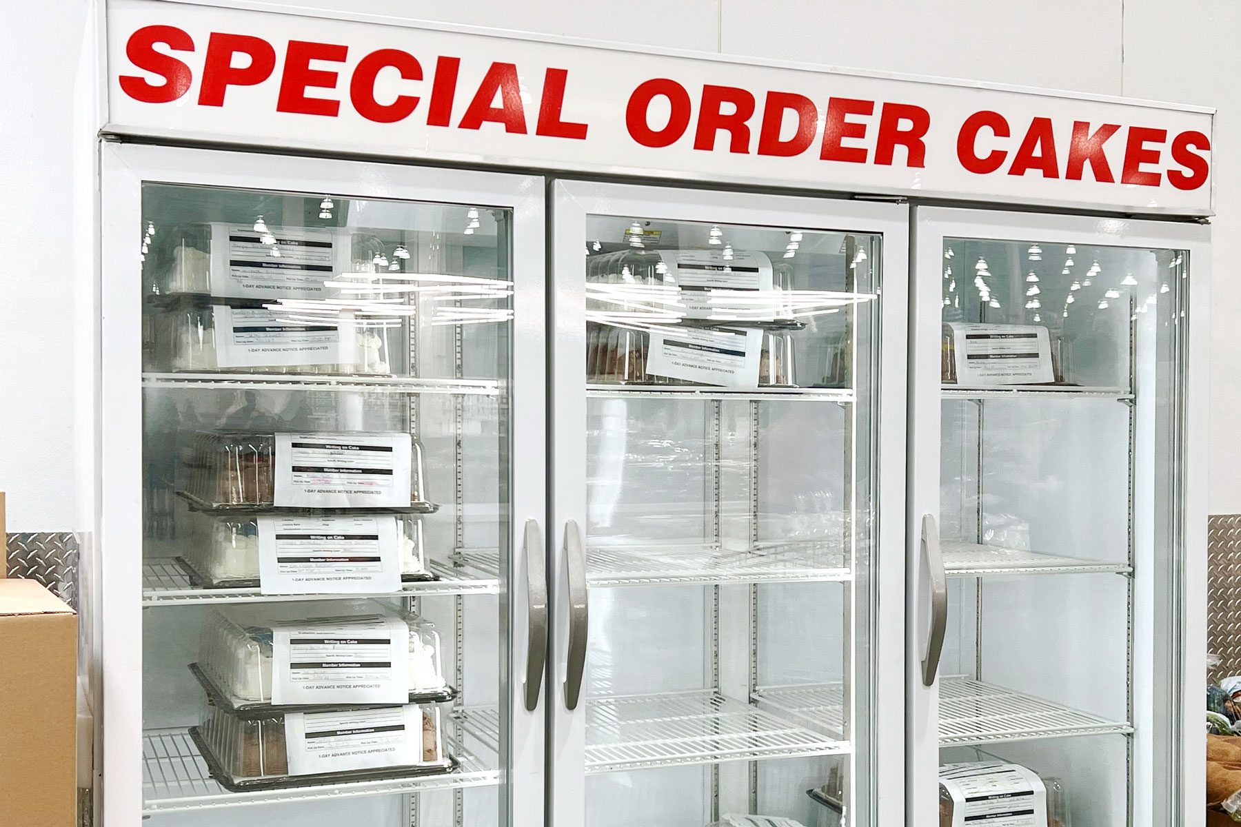 Special order cakes fridge at Costco with chocolate and vanilla sheet cakes inside