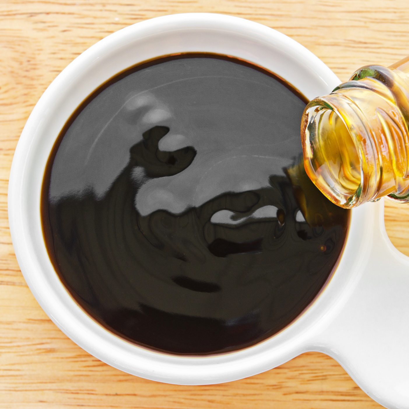 Oyster sauce being poured into white dish