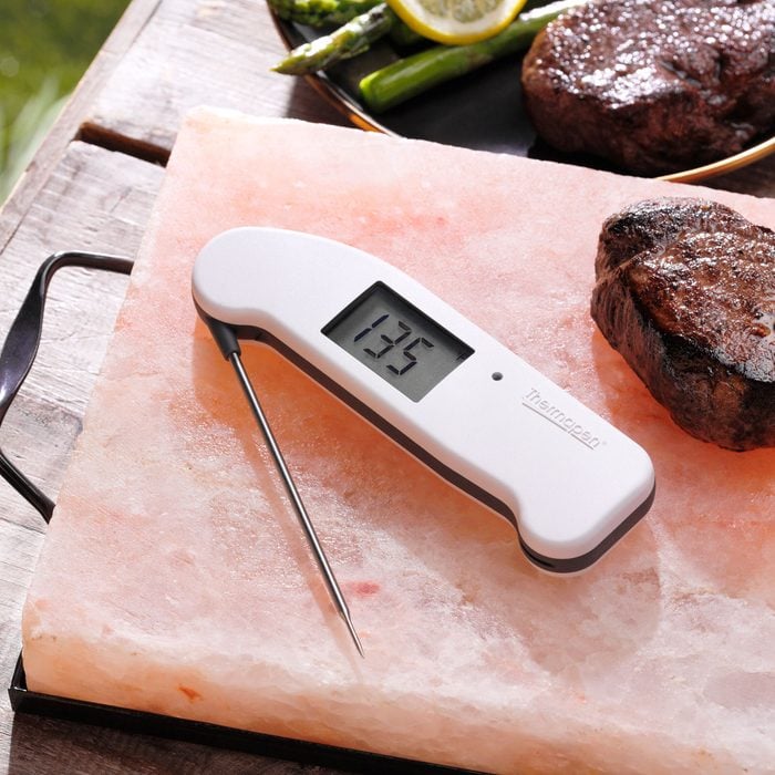 Thermapen on a salt block next to steak