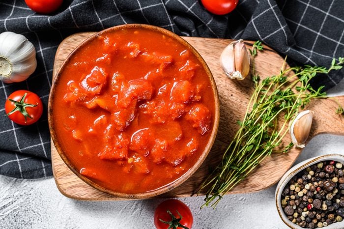 Bowl of diced tomatoes isolated on rustic white surface. White background. Top view