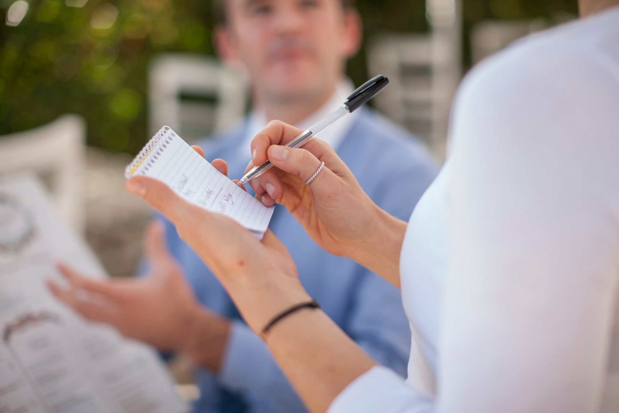 Waitress writing ordering on notepad, partial view