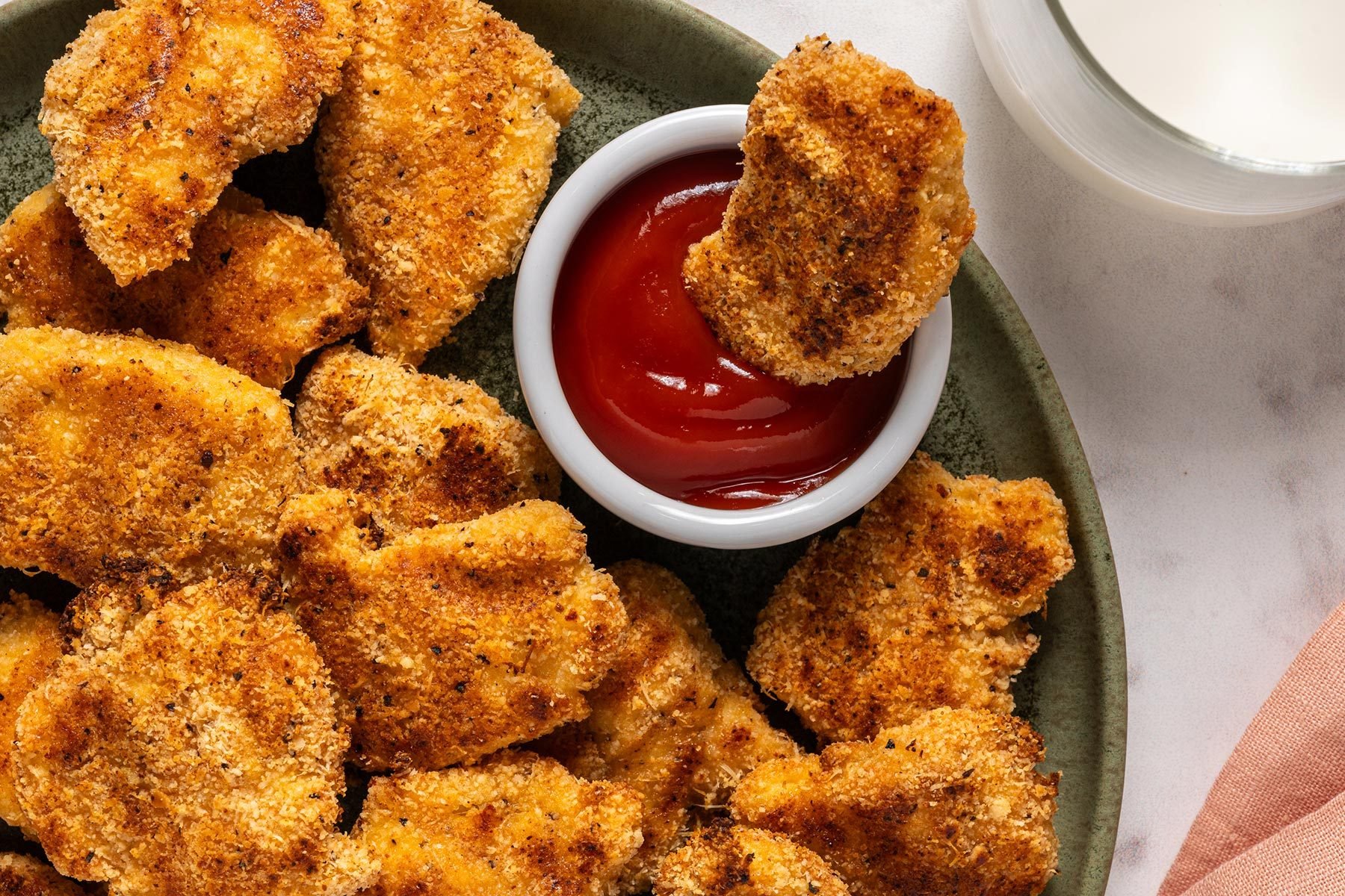 Plate full of chicken nuggets and a cup of sauce