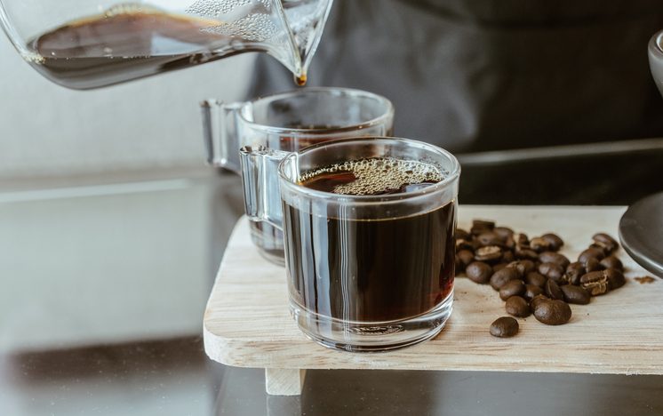 Cropped shot of Barista pouring a hot coffee after drip in a glass cup of coffee