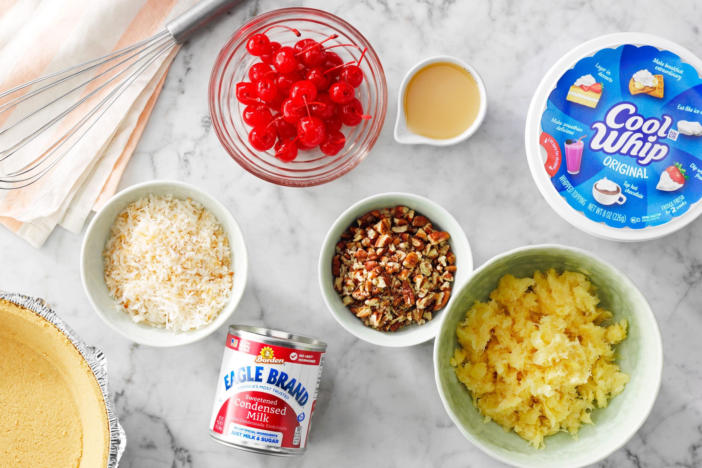 ingredients for million dollar pie measured out into small bowls on a kitchen counter
