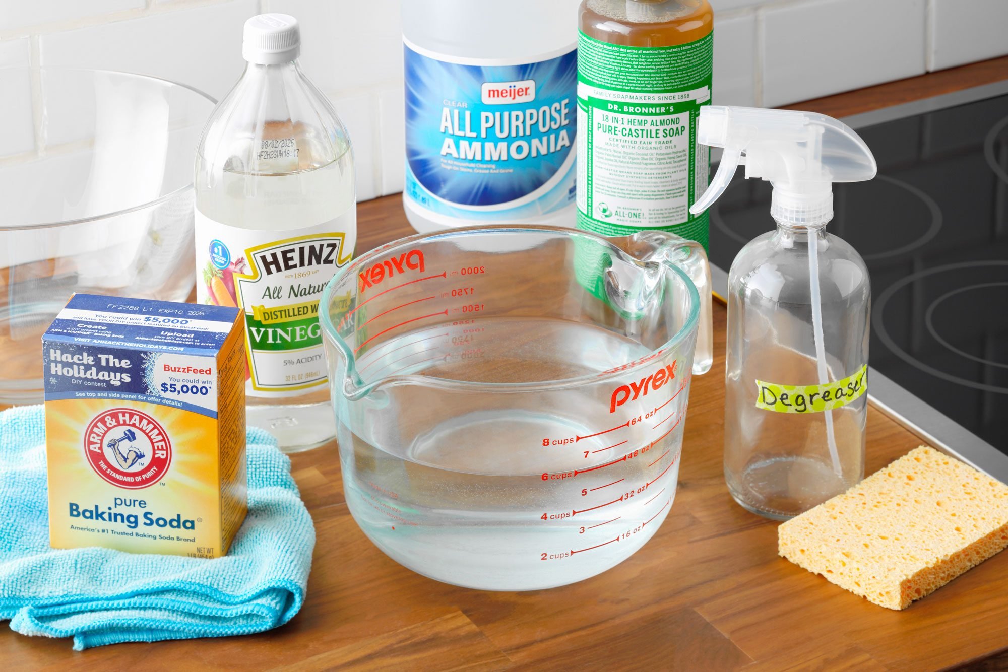 Homemade Cleaner degreaser ingredients arranged on a kitchen counter near a stove top