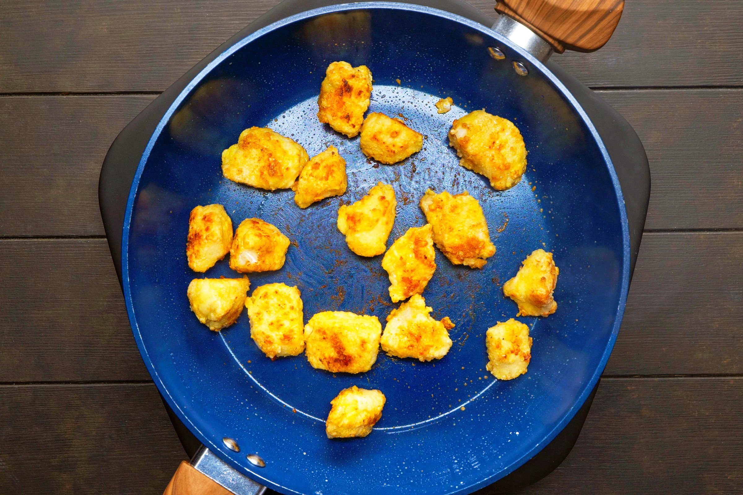 chicken frying in blue pan