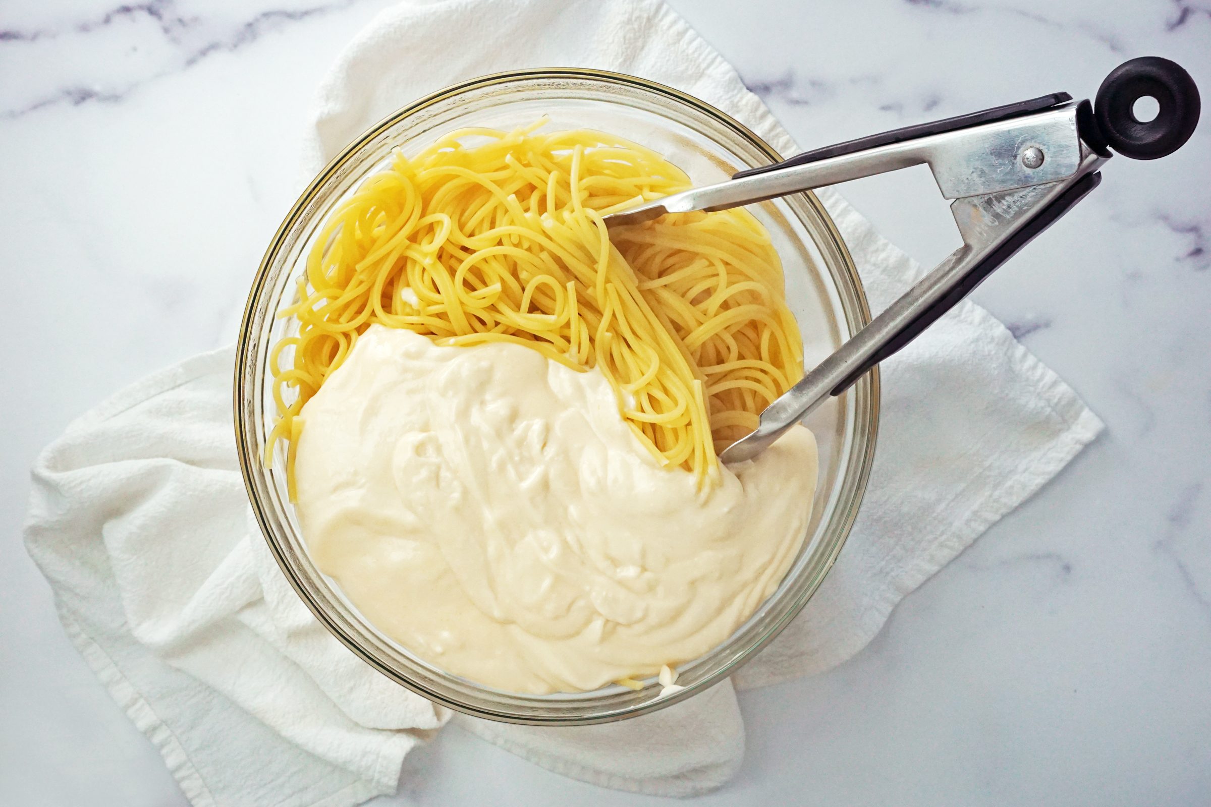 cooked pasta and Alfredo sauce in a bowl