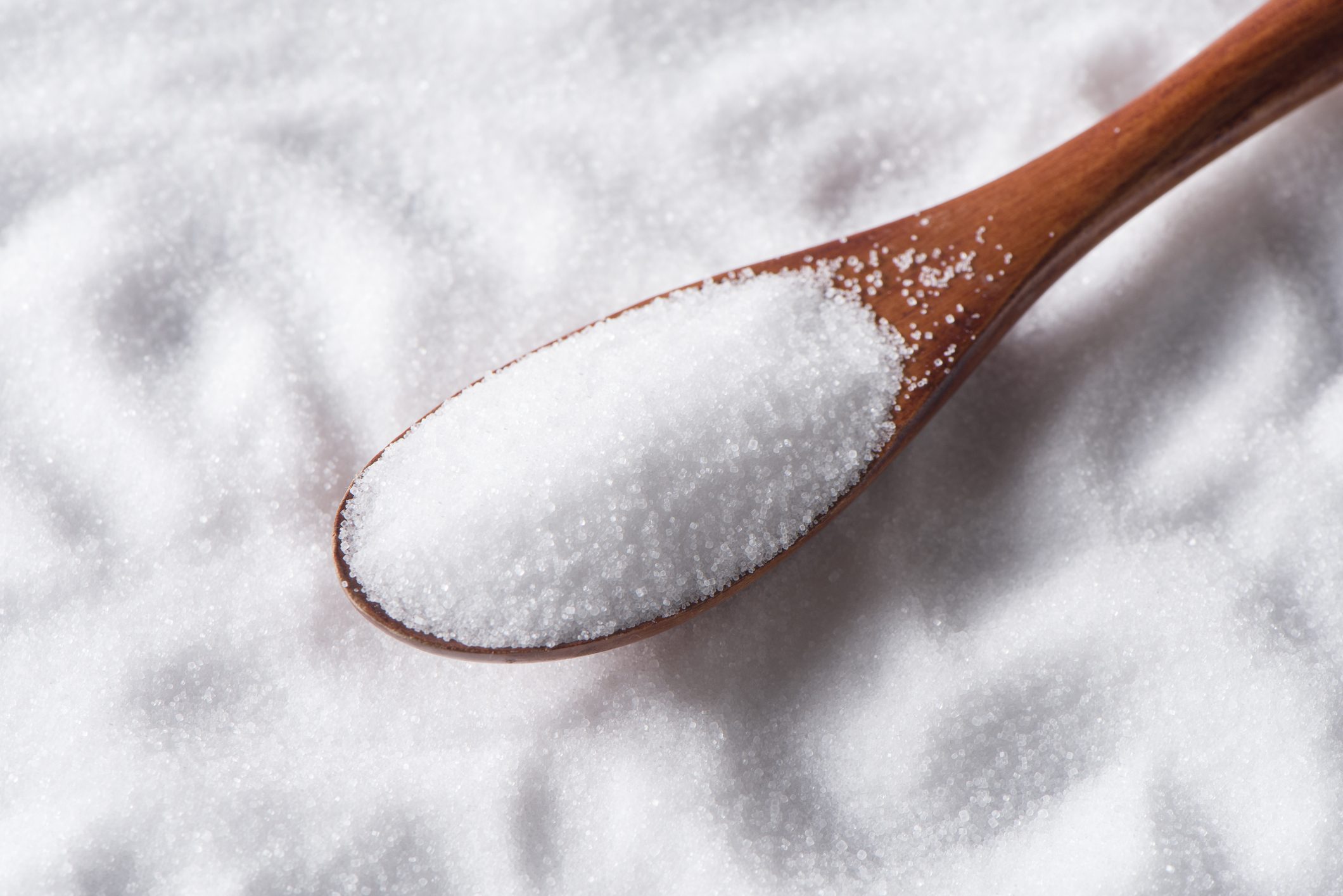 close up of salt in wood spoon on salt background