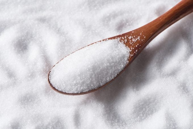 close up of salt in wood spoon on salt background