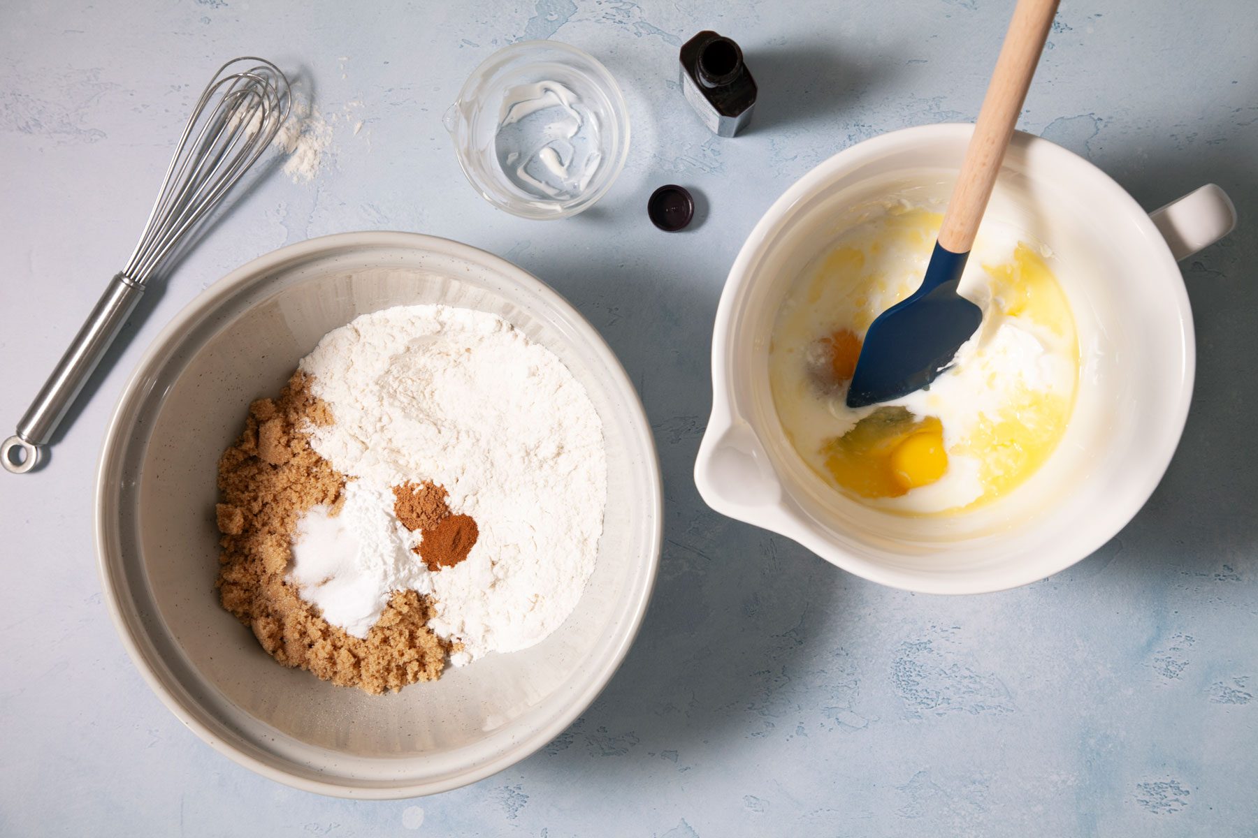 A Bowl of Dry Mixture and Eggs With a Whisk