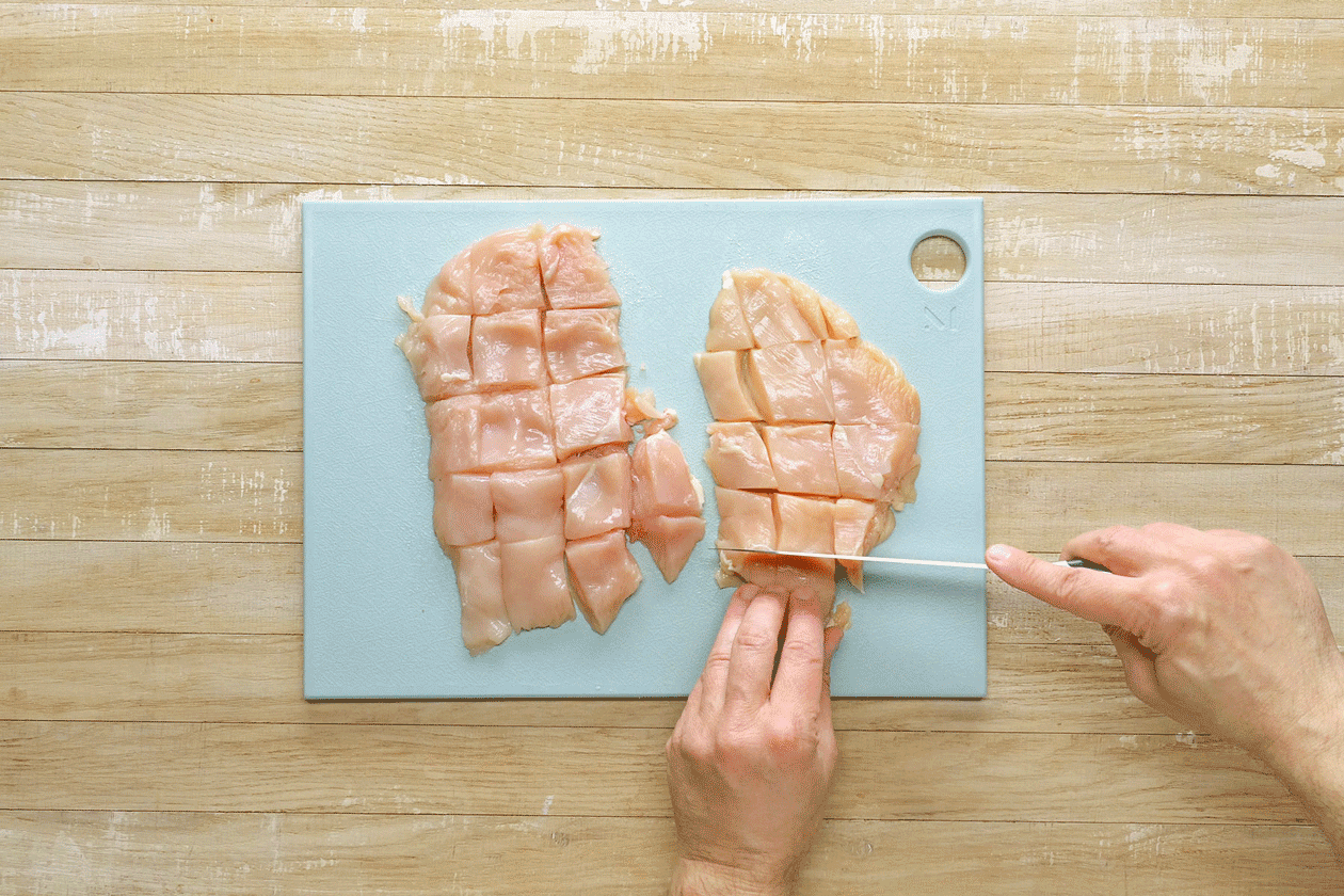 Cutting chicken into pieces and then coating them