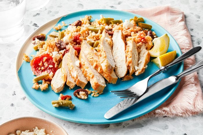 Mediterranean Chicken served in a plate with lemons and forks