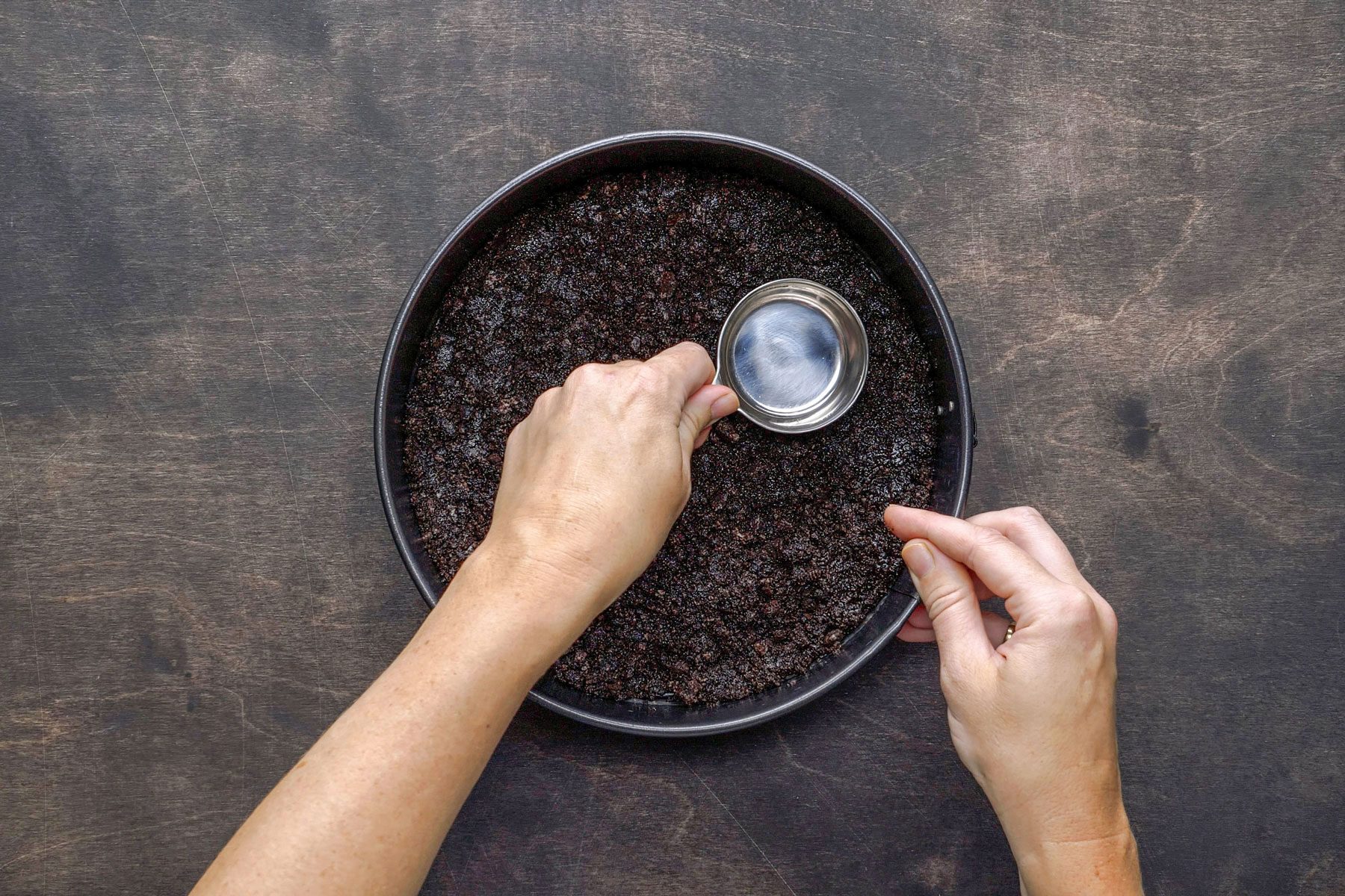 Pressing the oreo mixture in a pan