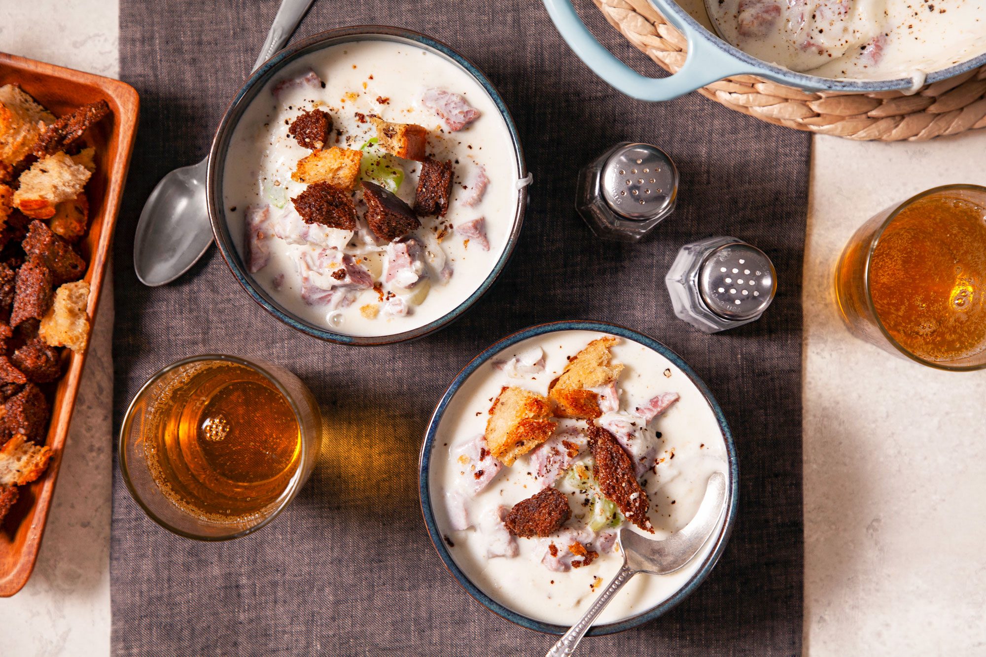 Reuben Soup Served in Two Bowls with Spoons on Dark Cloth on Marble Surface