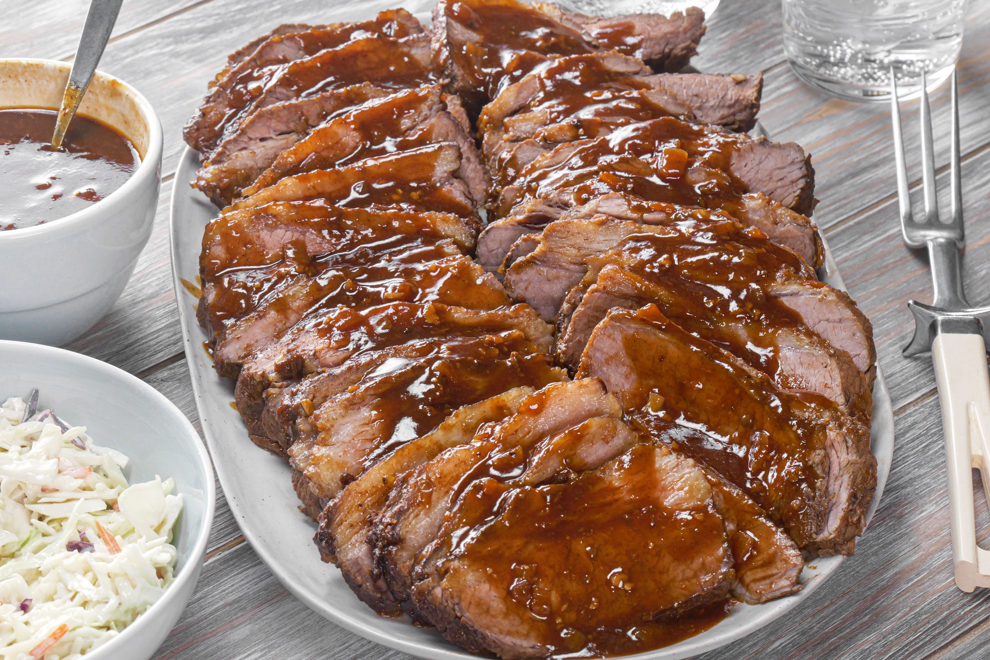 Slow Cooker Brisket served in a plate with barbecue sauce and salad